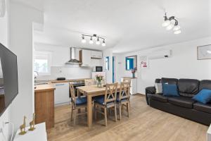 una cucina e un soggiorno con un tavolo e un divano di Apartman Žužić a Novigrad Istria
