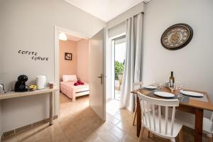 a dining room with a table and a clock on the wall at Prestige Holiday Apartments in Kos Town