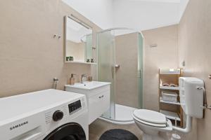 y baño con aseo, lavabo y ducha. en Apartman Žužić, en Novigrad Istria