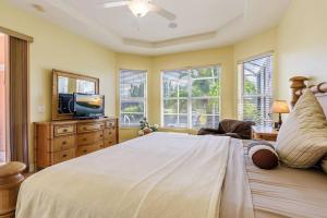een slaapkamer met een groot bed en een flatscreen-tv bij Villa Maxos - Boaters dream 4br/3 bath pool / spa in Cape Coral