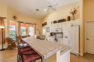 een keuken met een witte koelkast en een tafel bij Villa Maxos - Boaters dream 4br/3 bath pool / spa in Cape Coral