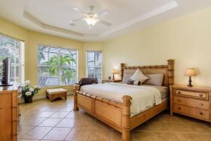 een slaapkamer met een bed, een bureau en ramen bij Villa Maxos - Boaters dream 4br/3 bath pool / spa in Cape Coral +37 foto's
