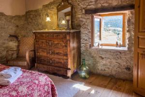 1 dormitorio con tocador de madera y ventana en Casa de Pedra Casa rural en el Alt Empordà, en Cantallops
