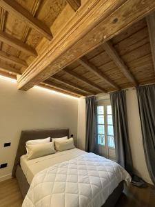 ein Schlafzimmer mit einem großen Bett und einem Fenster in der Unterkunft La Dimora del Brocante in Cuneo