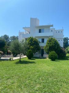 a large white building with trees in front of it at Casa Gazi in Ulcinj