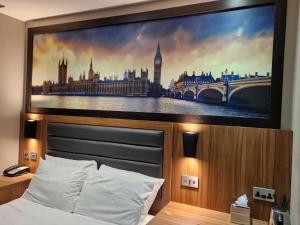 a bedroom with a large tv above a bed at London Court Hotel in London