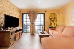 ein Wohnzimmer mit Couch und Flachbildfernseher in der Unterkunft Brisa del Mar in Guía de Isora