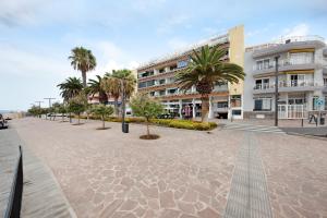 a street with palm trees in front of a building at Brisa del Mar in Guía de Isora