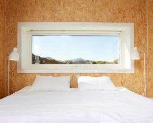 una camera con un letto bianco e una finestra di where the ocean meets land a Ramberg