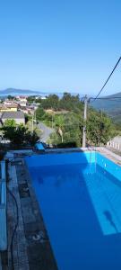 a blue swimming pool with a view of the ocean at Casa do Monte in Castro Daire