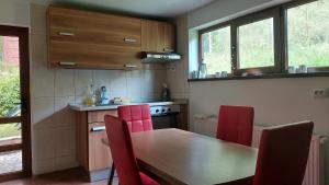 a kitchen with a wooden table and red chairs at Casa TEX in Buşteni