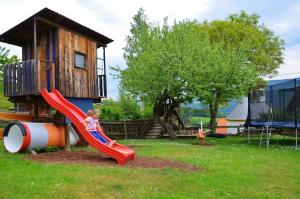 a young child on a slide on a playground at Ferienwohnungen Perhofer in Birkfeld