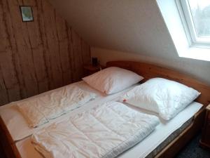 - un lit avec 2 oreillers dans l'établissement Nordsee-Ferienanlage-Wohnung-Baltrum, à Dornumersiel