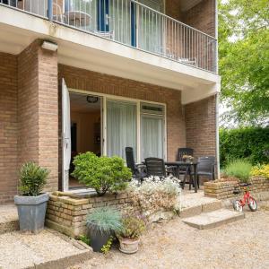 a house with a balcony with a table and chairs at Appartement Zuiderstrand in Zoutelande