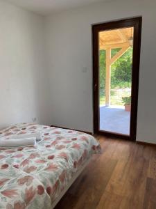 a bedroom with a bed and a door to a patio at Hill House Emir in Bihać