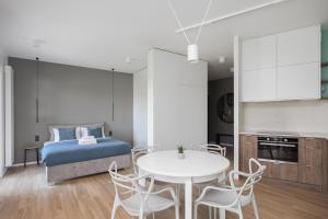 um quarto com uma cama, uma mesa e cadeiras em Okopowa Blue Apartment em Varsóvia