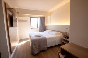 a hotel room with a bed and a window at Antonio´s Palace Hotel in Piracicaba