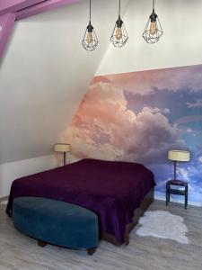 Un dormitorio con una cama morada y una pintura en la pared. en Le Montmieri, en Dax