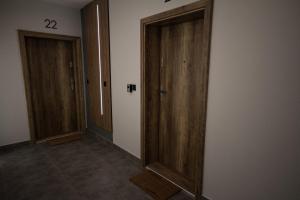 einen Flur mit zwei Holztüren in einem Zimmer in der Unterkunft Apartamenty Lesko 23 in Lesko
