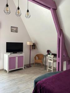 um quarto com uma cama, uma televisão e uma mesa em Le Montmieri em Dax