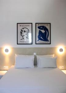 a white bed with three pictures on the wall at Lithi Stylish Apartments- Eco Luxury Suite in Tripití