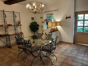 a dining room with a glass table and chairs at Moulin des Faurilloux in La Chapelle-Faucher