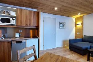 een keuken en een woonkamer met een bank en een tafel bij Douillet 33 m² piscine et sauna - 6 pers in Huez