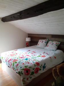 a bedroom with a bed with flowers on it at Moulin des Faurilloux in La Chapelle-Faucher