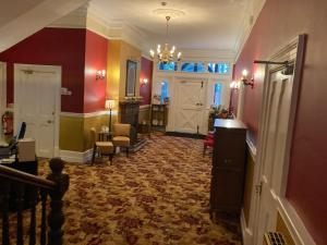 een hal met een kamer met rode muren en een deur bij The Grange Hotel in Bury Saint Edmunds