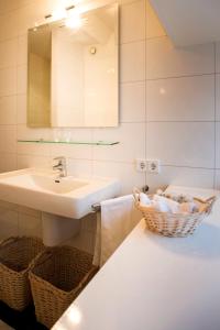 a bathroom with a sink and a basket of towels at PetitGrandeur in Maastricht