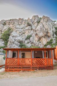 a house in front of a rocky mountain at Mobile home MARIS in Sveti Juraj