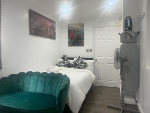 曼徹斯特的住宿－Dynasty Lodge，一间卧室配有一张床和一张绿色沙发