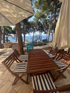 two chairs and a wooden table and an umbrella at Apartman Zlatan in Sveta Nedelja