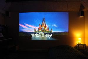 einen TV-Bildschirm mit einer Disney Castle drauf in der Unterkunft Large modern family room - “Arnely” in Tommerup