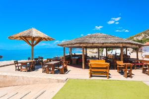 a restaurant with chairs and tables and umbrellas on the beach at Mobile home MARIS in Sveti Juraj