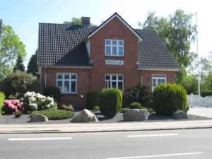 een rood bakstenen huis met stenen ervoor bij Large modern family room - “Arnely” in Tommerup