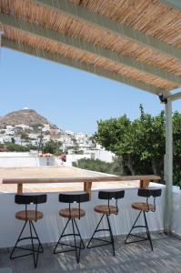 a wooden table and four stools on a patio at Lithi Stylish Apartments- Eco Luxury Suite in Tripití