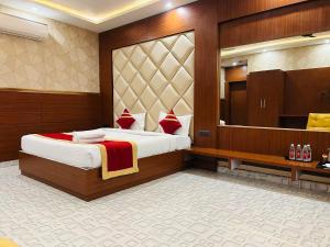 Pokój hotelowy z łóżkiem i dużym lustrem w obiekcie Royal Heritage Hotel & Resort w mieście Ayodhya