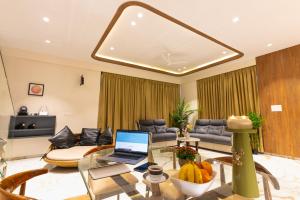 a living room with a laptop on a glass table at Villa Amara 30 by Stay ALYF, Lonavala in Lonavala
