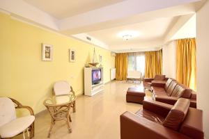 a living room with a couch and a tv at SeaX Stay Apartment - free parking in Mamaia Sat/Năvodari