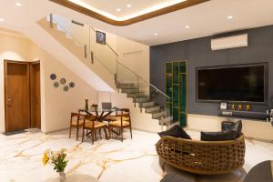 a living room with a staircase and a table and chairs at Villa Amara 30 by Stay ALYF, Lonavala in Lonavala