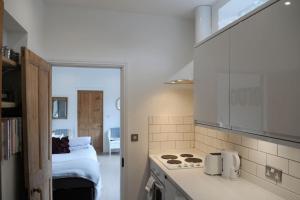 a kitchen with a stove top oven next to a bed at The Snug in Riccall