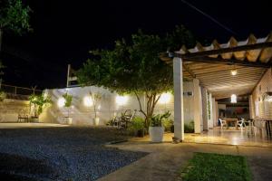 a patio at night with a table and a tree at Pousada dos Ventos Refugio Urbano in Cuiabá