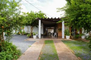 un patio de una casa con mesa y sillas en Pousada dos Ventos Refugio Urbano en Cuiabá
