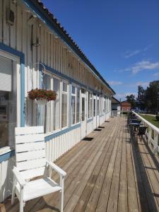 a white bench on a wooden deck next to a building at Lainela Holiday Park in Käsmu