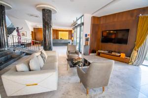 a living room with a couch and chairs and a tv at Dorana Hotel in Kérynia
