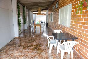 um pátio com uma mesa e cadeiras e uma parede de tijolos em Pousada dos Ventos Refugio Urbano em Cuiabá