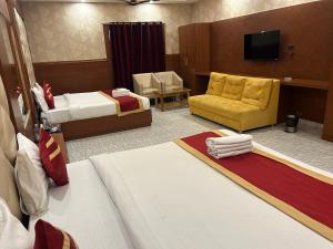 a hotel room with two beds and a television at Royal Heritage Hotel & Resort in Ayodhya