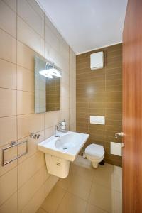 a bathroom with a sink and a toilet at SeaX Stay Apartment - free parking in Mamaia Sat/Năvodari +33 photos