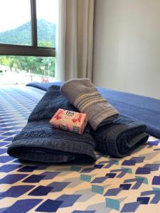 ein Stapel Handtücher auf einem Bett in der Unterkunft Rio Marina Resort in Itacuruçá + 27 Fotos